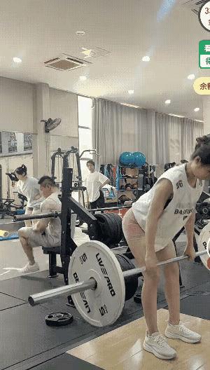 这讨厌的摄像头坏了我的好事……
健身房里，一位身材姣好的女生正在做杠铃硬拉，一位
