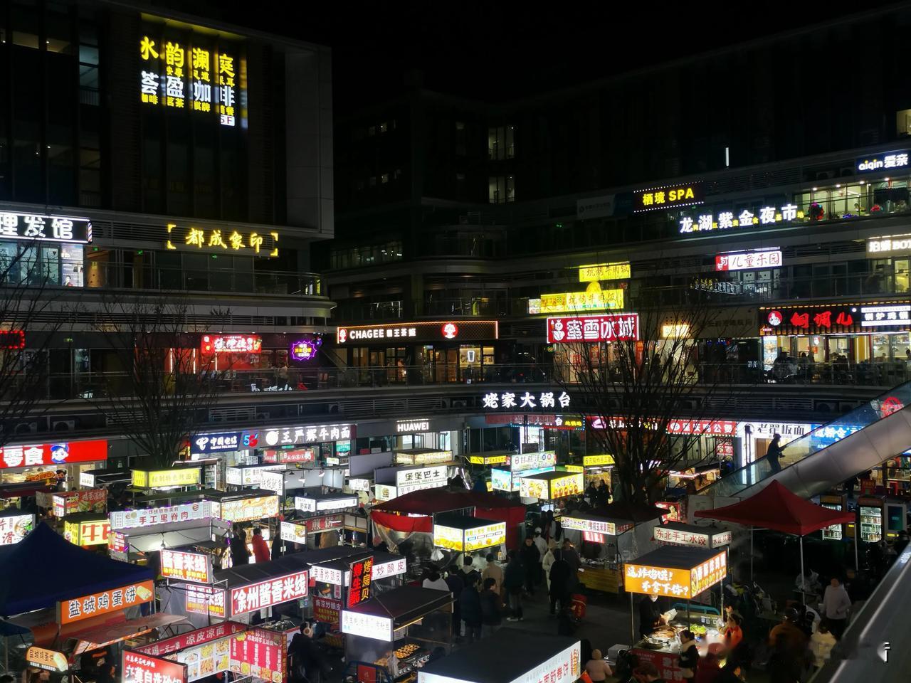 经济面临寒冬，夜市烟火正浓。过龙湖天街，感受夜市经济，夜幕下的广场，灯火通明，人