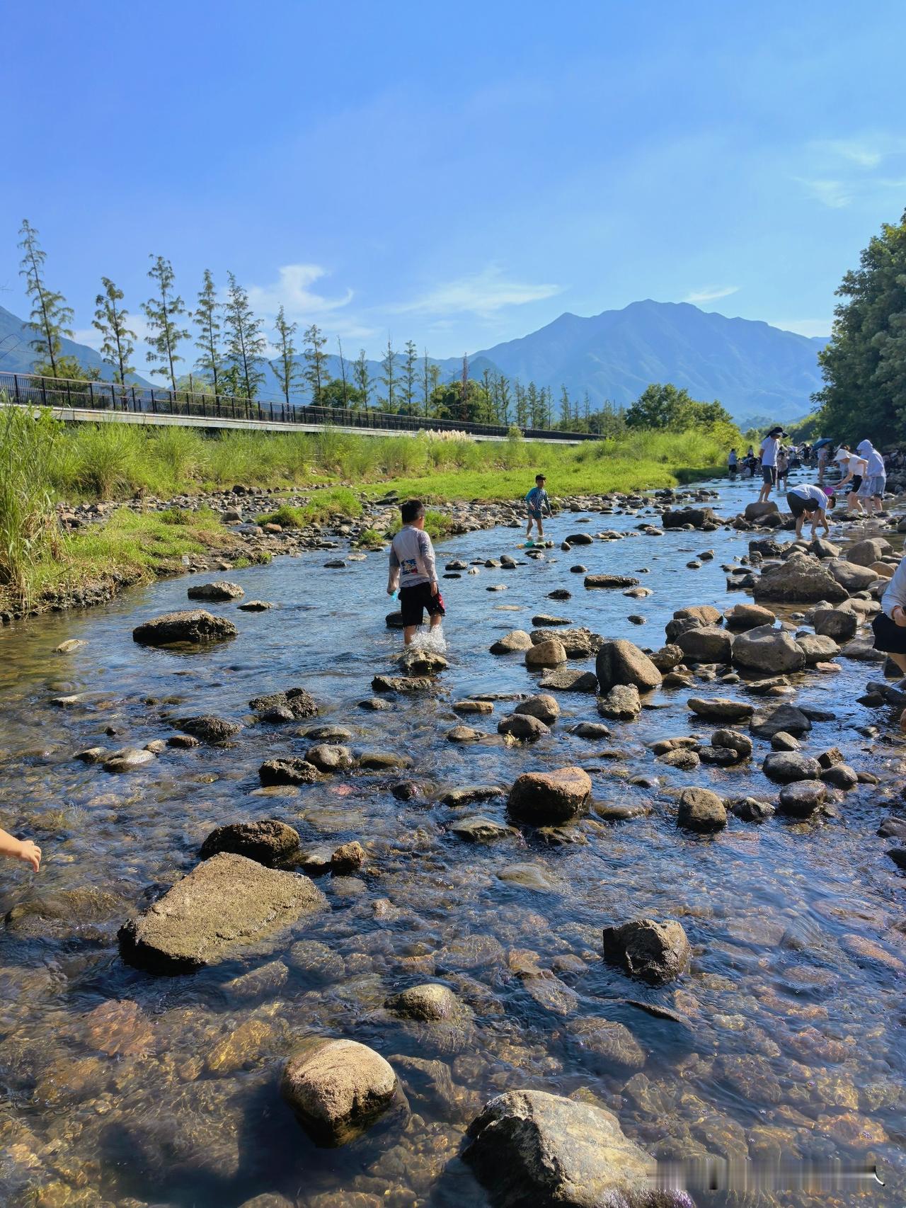 朔溪玩水，山里人家亲子消暑活动，外地游客到景点排队玩水，本地人水边桥下随处都是好