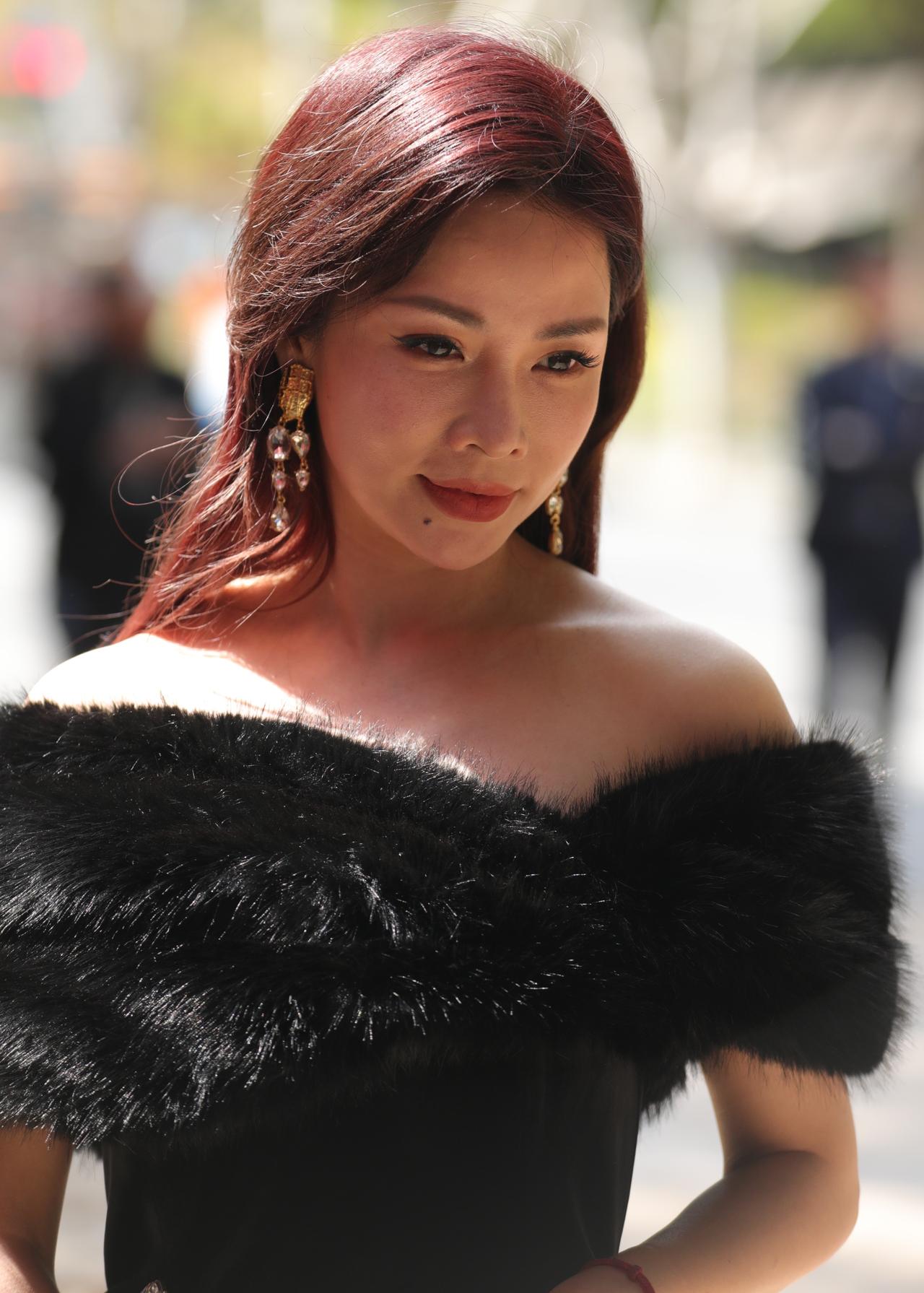 黑绒与玫瑰
黑色抹胸礼服衬得肌肤胜雪，肩头的黑貂毛披肩随着她的动作轻颤，柔软而贵