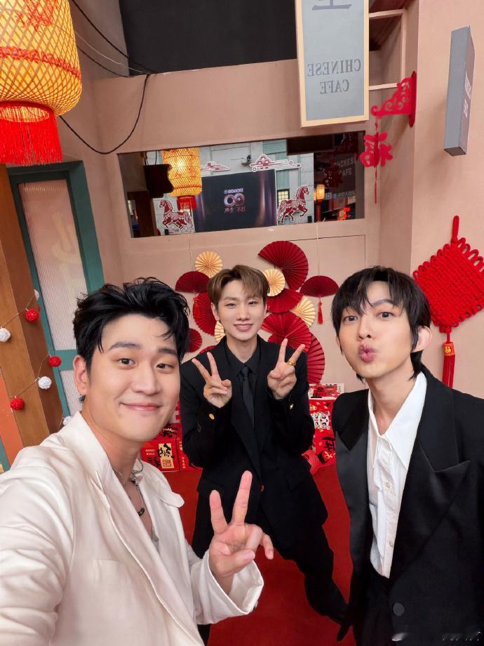周兴哲晒汪苏泷林宥嘉合照声生不息 红背景衬得三位格外精神，黑白西装又添了几分正式