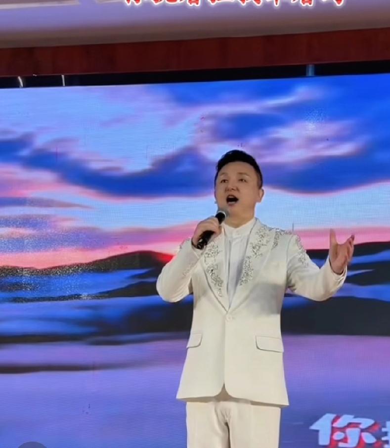 九哥在南京参加文旅慰问演出时，演唱经典歌曲《敢问路在何方》，他身着一身白色西服，