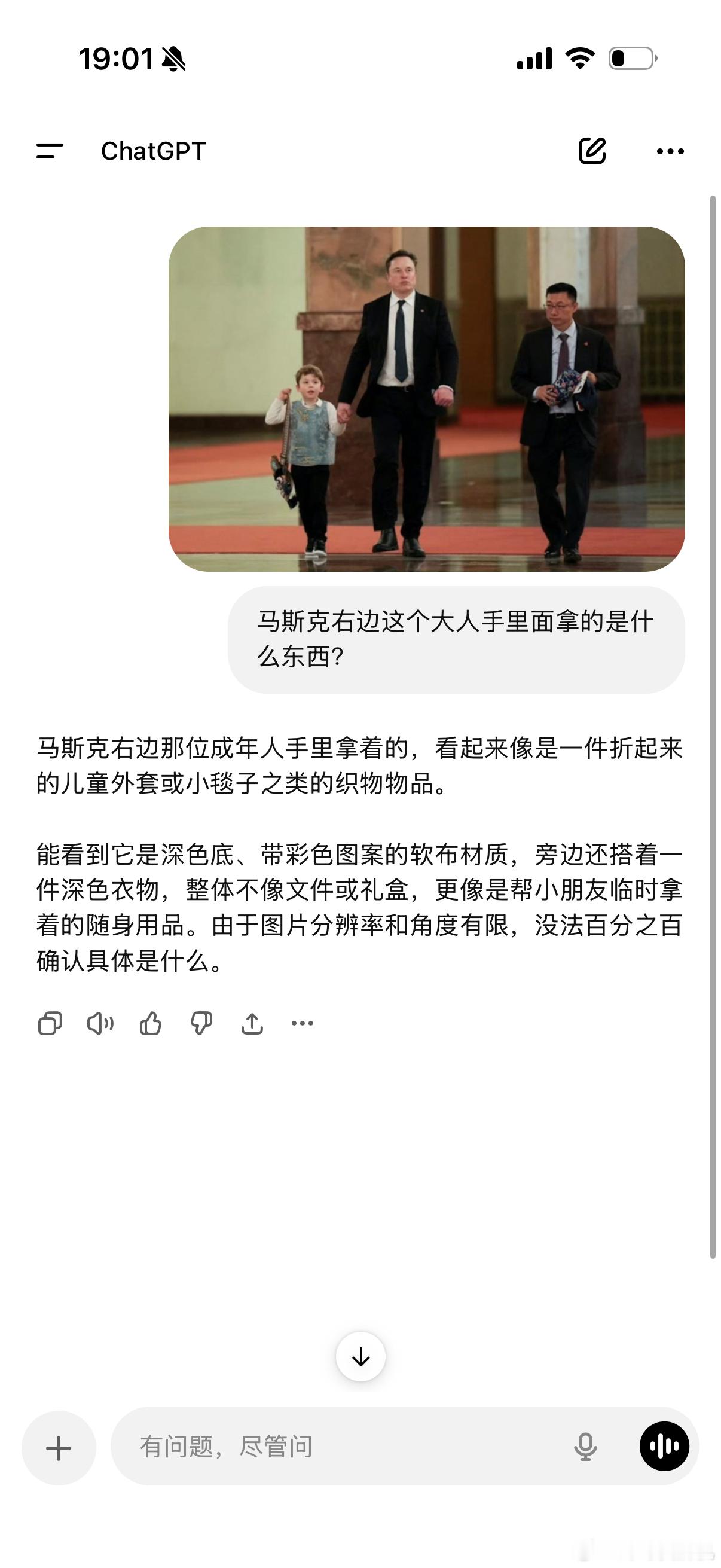 马斯克携幼子现身人民大会堂马斯克旁边的特斯拉全球副总裁手里拿的是什么东西？看豆包