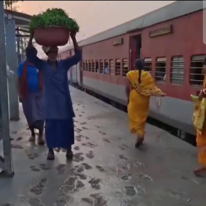 印度铁路站台，火车停靠在刚浇了混凝土的站台上，还湿漉漉的呢，火车照样停，乘客照样