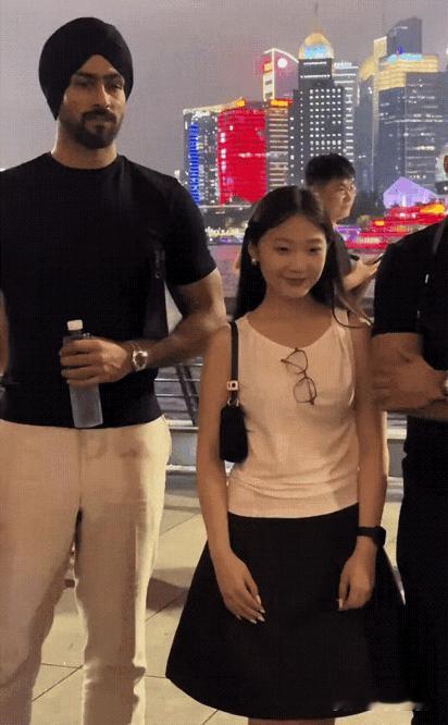 今晚外滩夜景黯然失色，两位印度游客反倒成焦点，不少姑娘排队争相合影，快门声盖过江