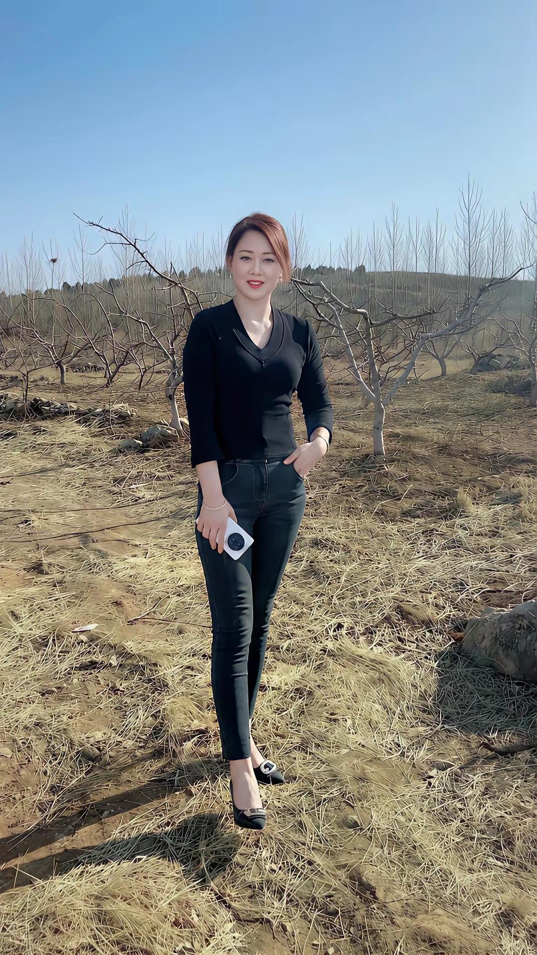 冬日暖阳下的时尚穿搭，黑色上衣搭配牛仔裤，轻松自在。