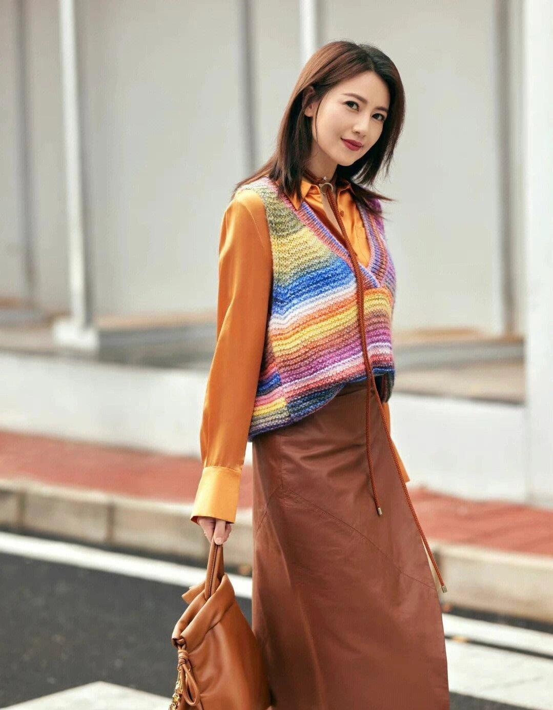 高圆圆这身穿搭真的太美了

彩虹针织马甲内搭橙色衬衫，下装搭配棕色皮裙，再配上同
