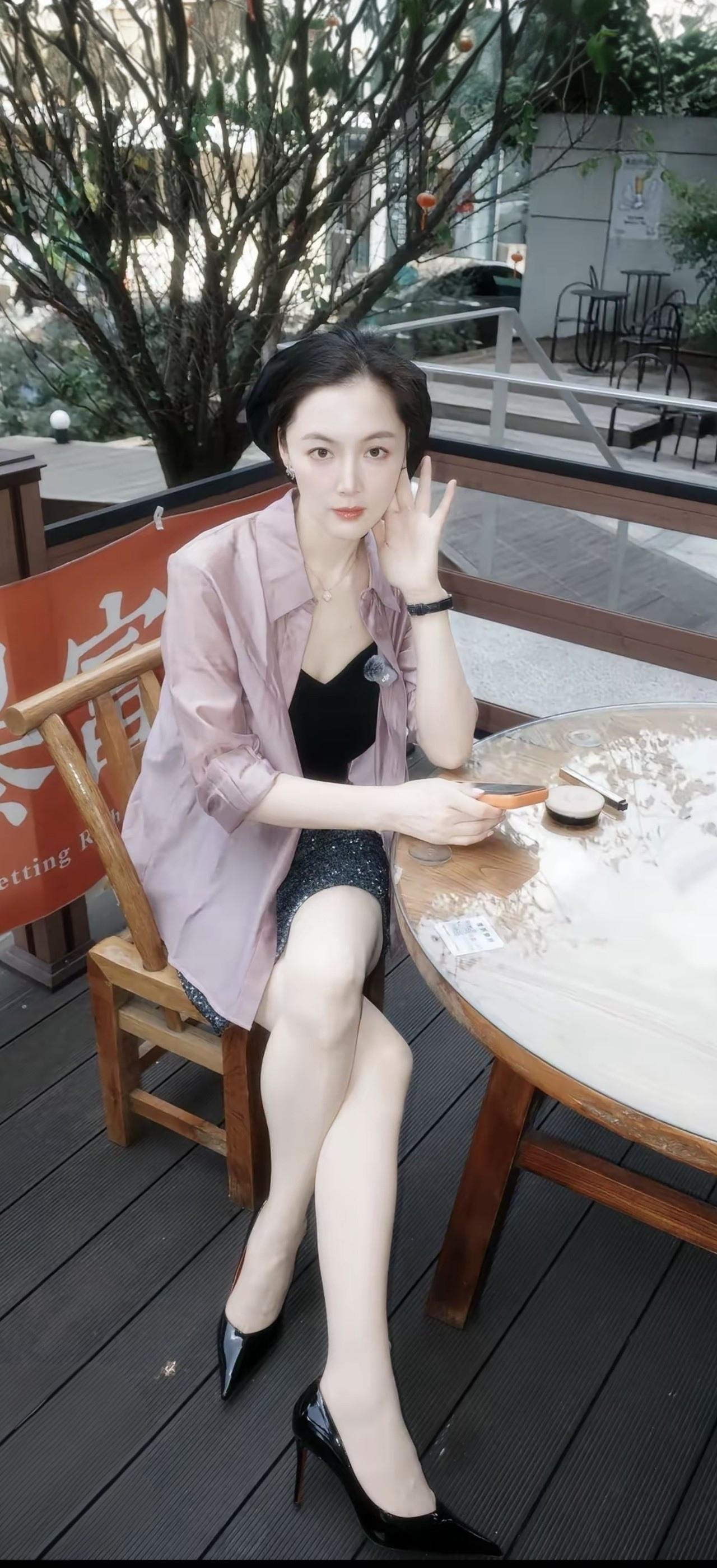 她坐在咖啡馆，手托着下巴。
