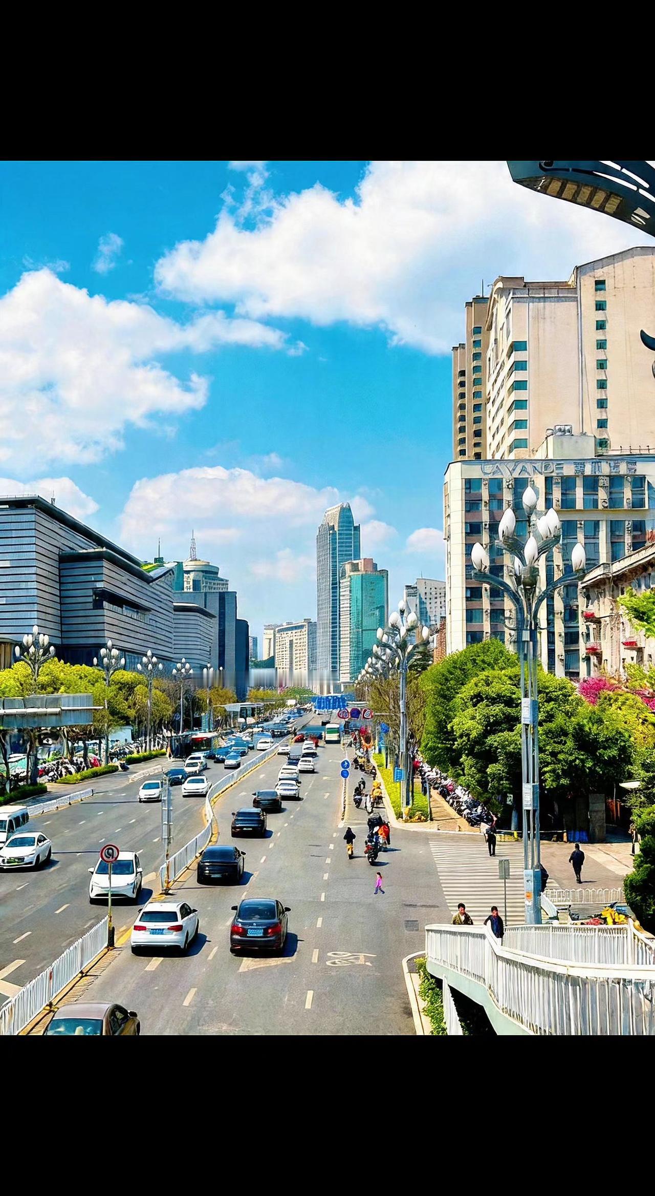 🌆云絮在楼宇间游走，车流是城市的脉搏。风掠过树梢，摇晃着盛夏的序章🍃