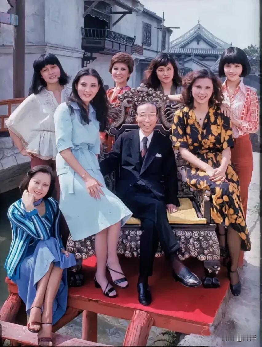 邵逸夫和七名美女合影，仔细看邵逸夫做在一把老式的椅子上脸上露出笑容。七名美女中看