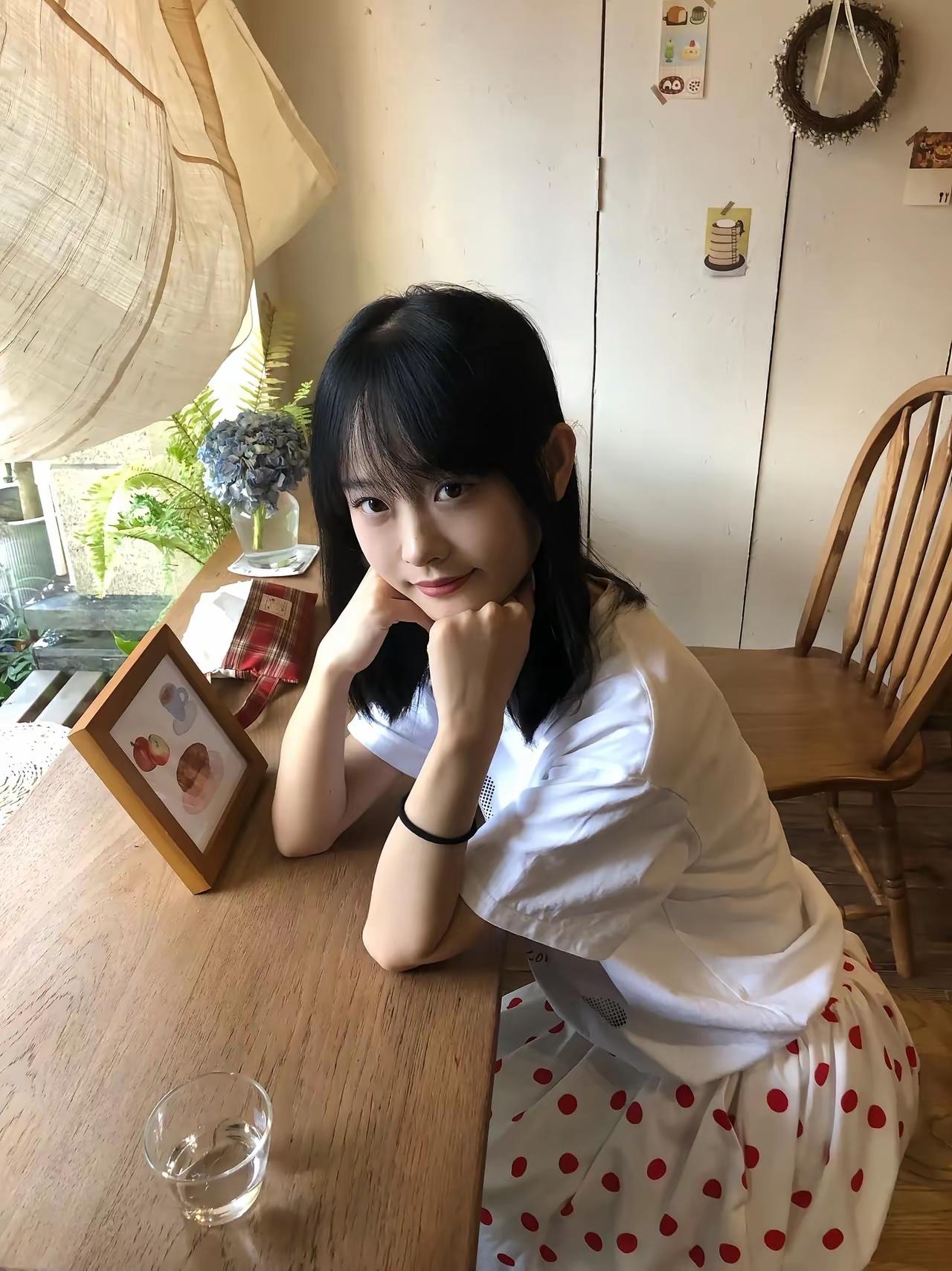 一位女孩在窗边喝咖啡。