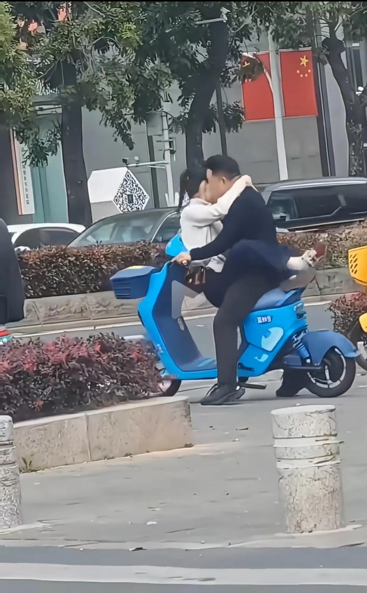 一对男女，坐在路边扫码的电动车上，女人坐前面，搂着男人的脖子，更换各种姿势，也没