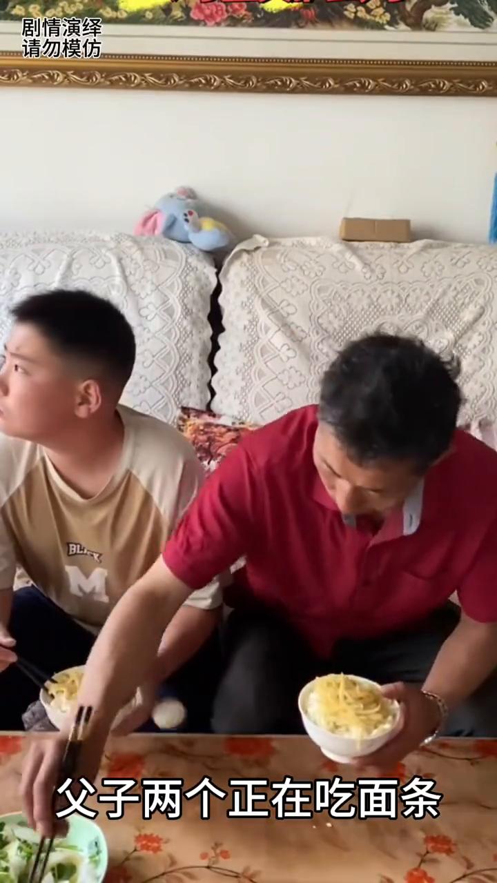 爸爸悄悄把儿子的鸡蛋吃掉了。
父子两个正在吃面条，这时儿子吃饭一直看电视，于是爸