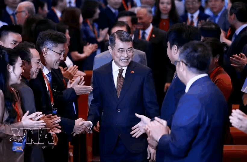 黎明兴在欢呼声中步入会场，并与部分参会者握手，全程笑容满面。