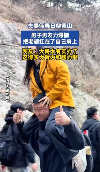 一对夫妻在爬黄山时，妻子累了丈夫就把老婆扛在肩上爬。看视频明显是摆拍的。最关键的