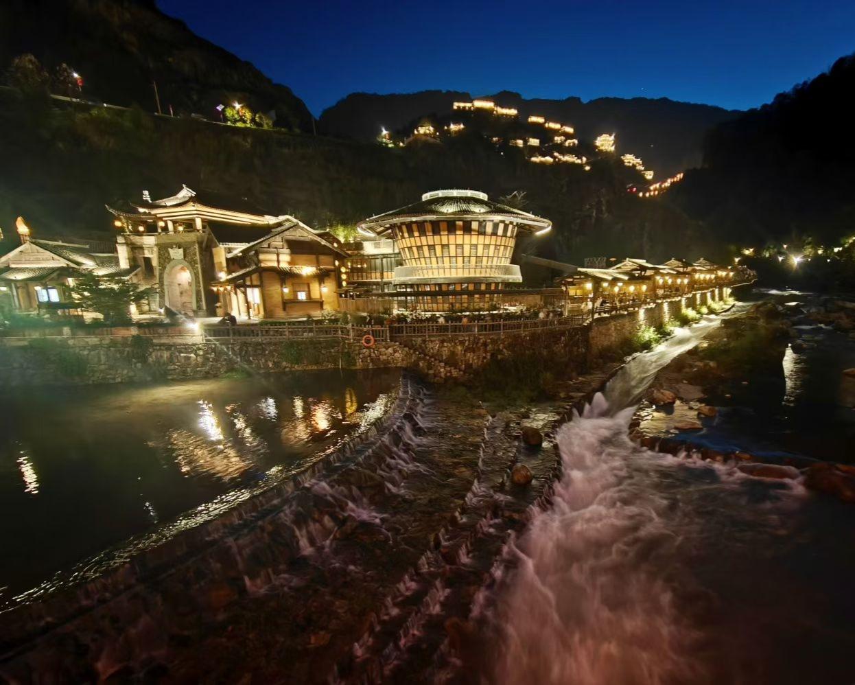 晒图大赛夜幕垂落，山乡灯火次第亮起。溪流载着碎金般的光影奔涌而下，古建飞檐映着暖