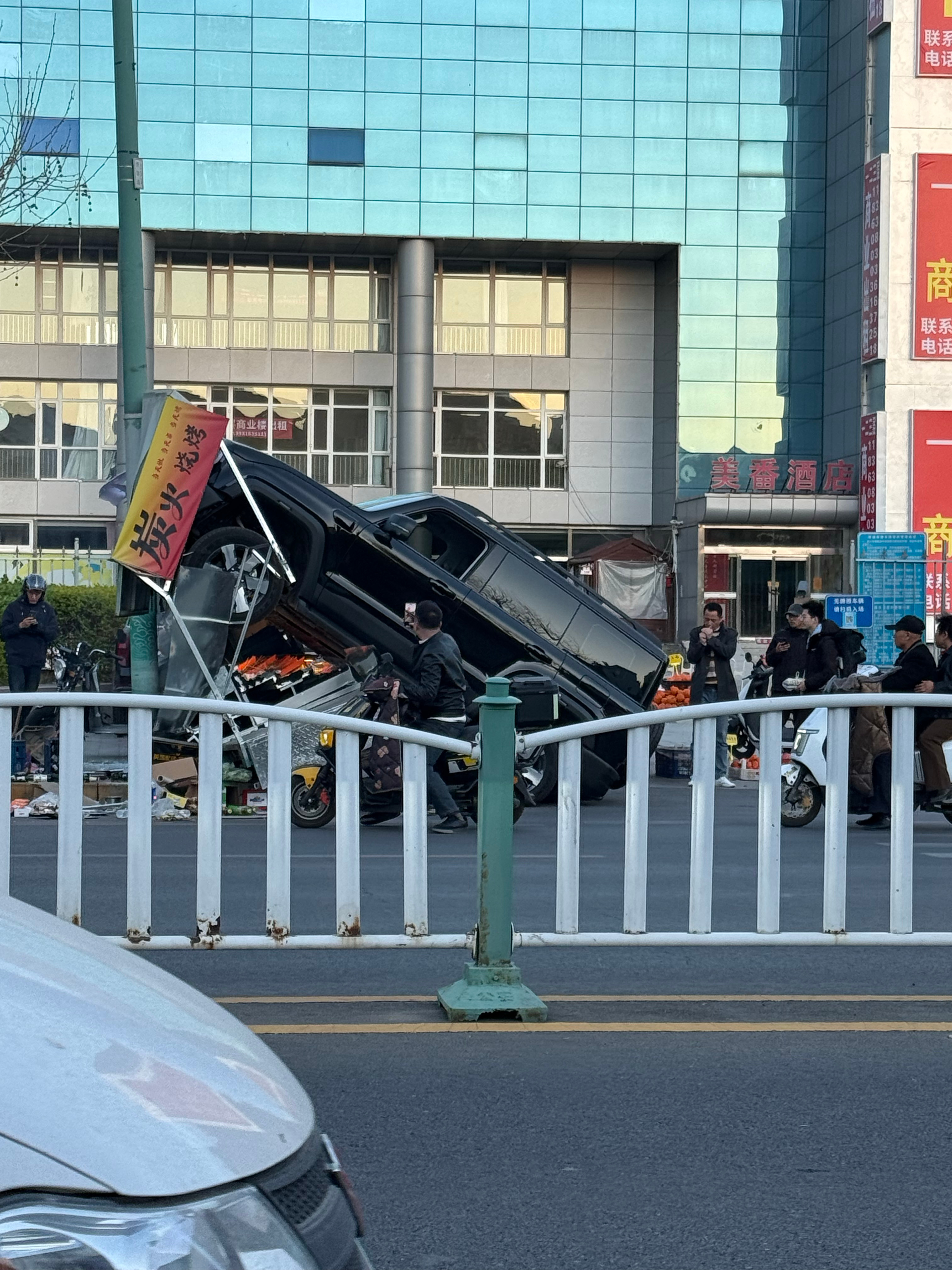 不是这个哥们开车走神了吗？怎么能开人家小摊上去啊？ 