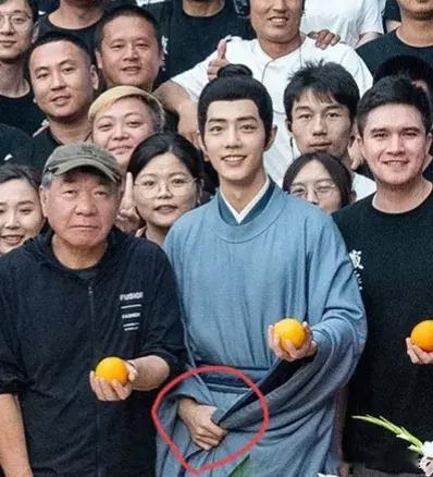 细节见人品，肖战合照的时候，因为左手要拿着橘子，右手就紧紧的拽着衣袖，他怕自己的