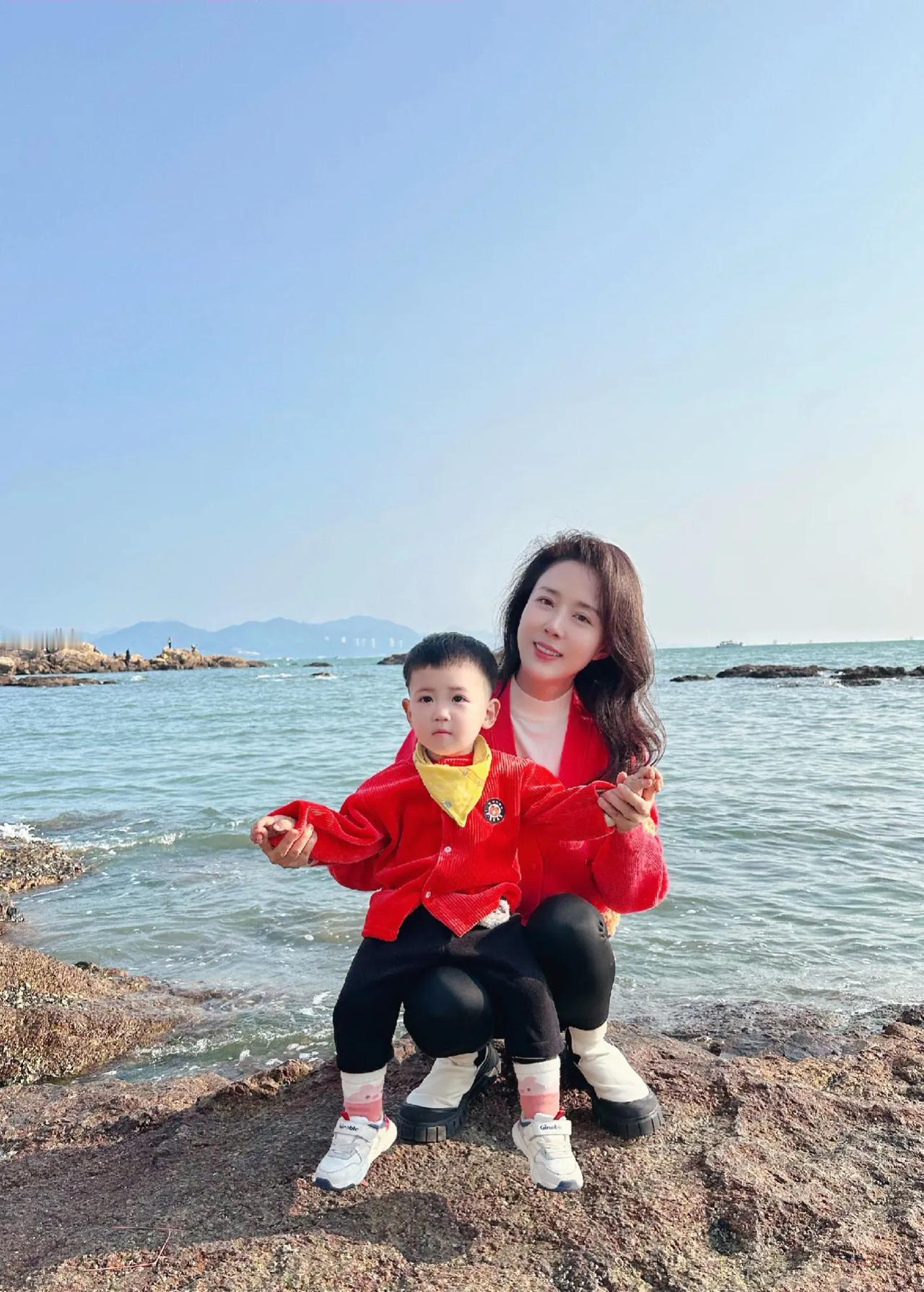 演员颜丹晨带着儿子来到海边玩耍，母子俩穿着红色亲子服，很是喜庆。不愧是当年的北电