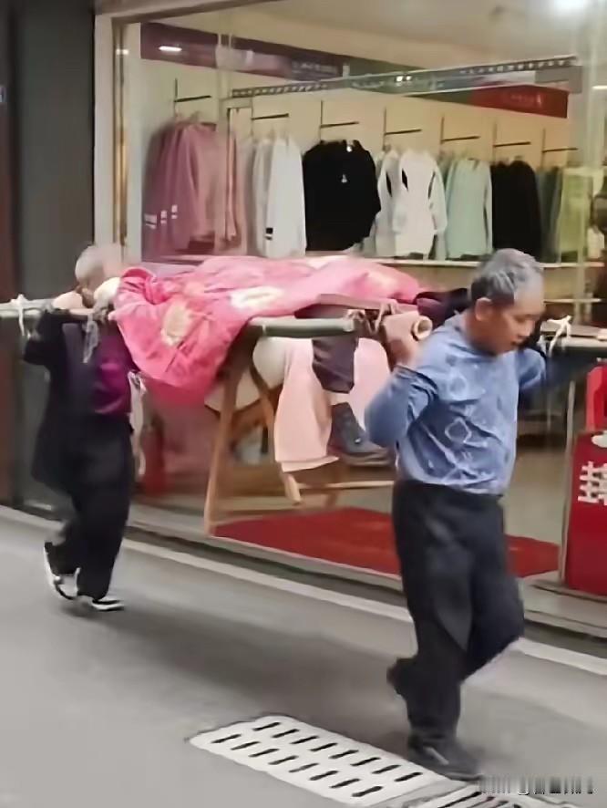 两兄弟抬94岁老娘去医院看病，看完病又抬回家，大哥72岁抬后面二弟快70岁抬前面