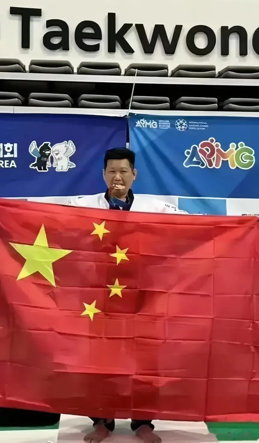 韩国举办的国际跆拳道比赛中，中国台湾省选手李东宪获得铜牌，赛场高举五星红旗说:作