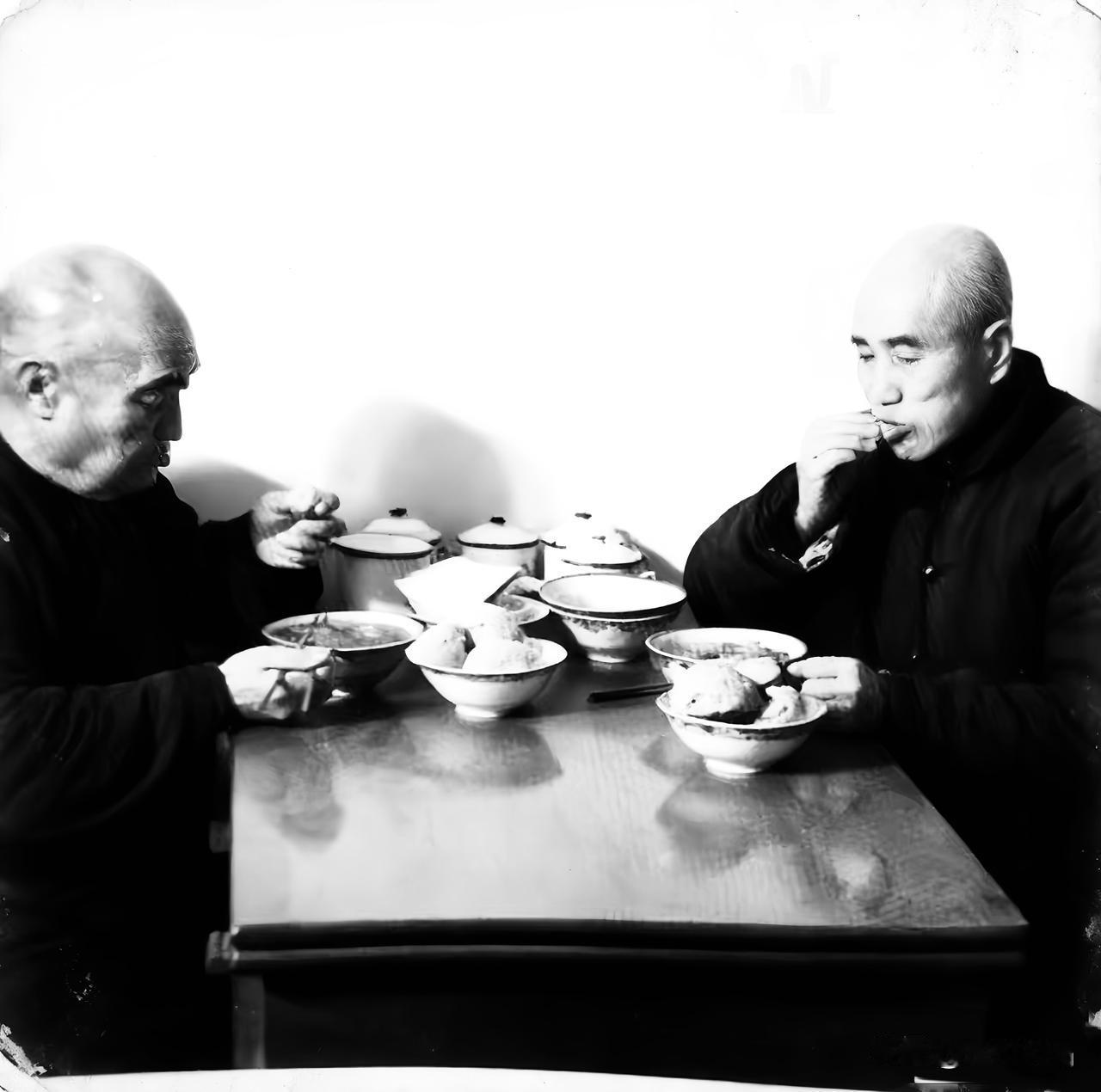 这是一张拍摄于功德林的老照片，时间是上个世纪五十年代，镜头里两位埋头“干饭”的老