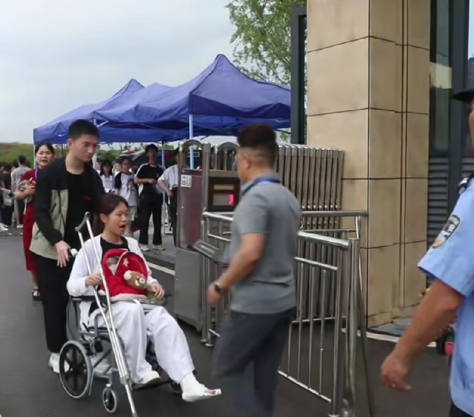 高考考场门口，一名男生推着坐在轮椅上的女生出现时，瞬间引来众多赞佩的目光。

湖