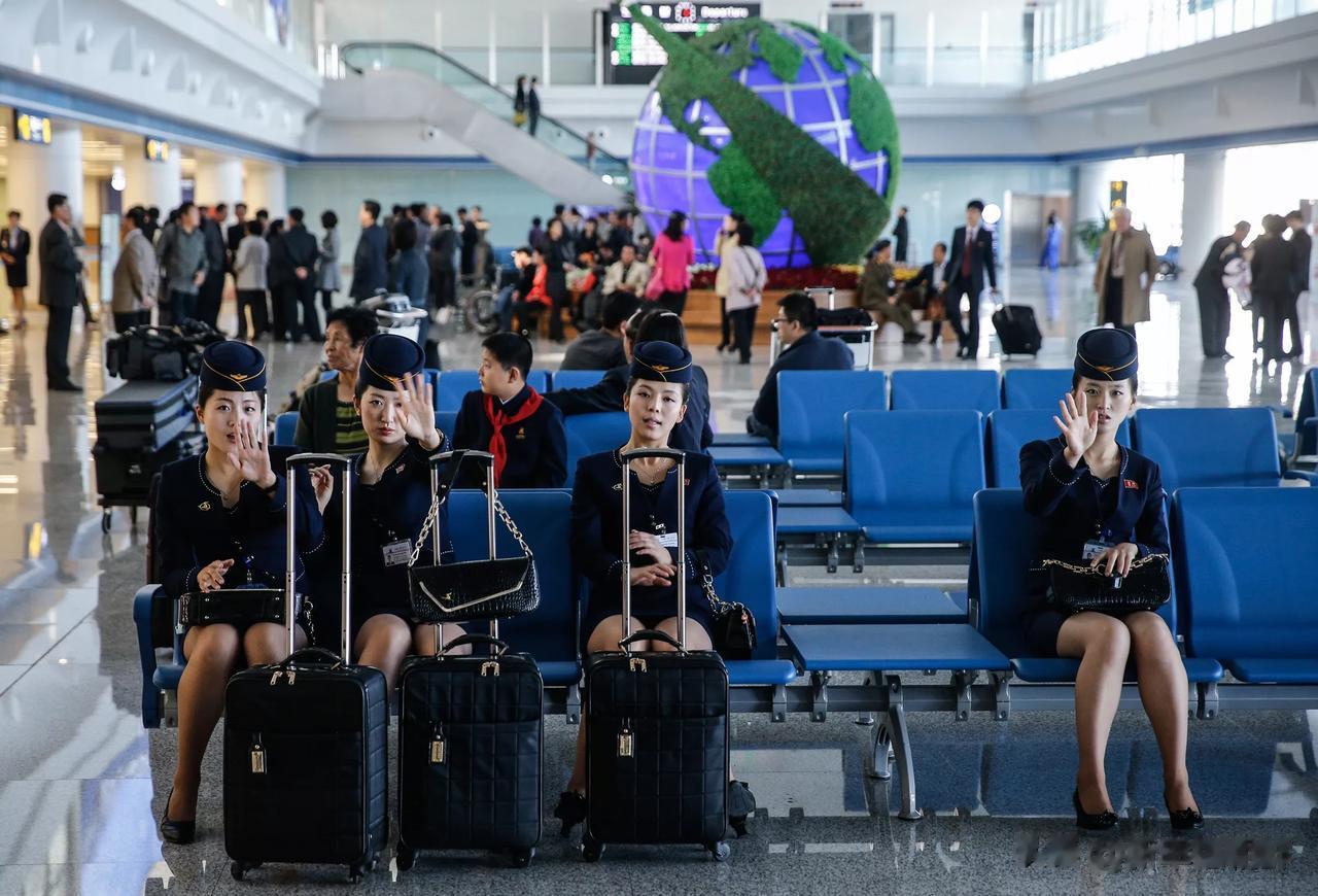 坐在机场等待起飞的朝鲜空姐，这是举手向你致意吗