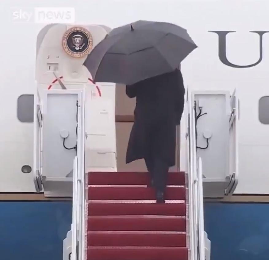 这哥在登机时笨拙地处理并丢弃雨伞，这是收下伞都不会还是没时间？雨伞在风中左右摇摆