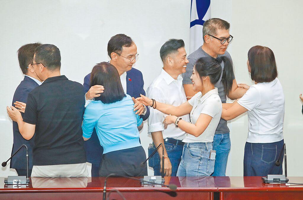 国民党挺过第一波大罢免。图为朱立伦26日日发表谈话后与北市立委互相拥抱祝贺。