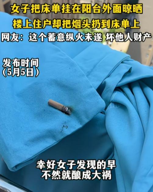 烟民就这么没公德心了吗？

一女子把床单挂在阳台外面晾晒，楼上住户却把烟头扔到床