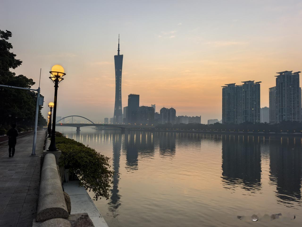 晨曦为二沙岛镀上一层柔光，珠江水面泛着粼粼金波，将广州塔的倩影轻轻托起。红色塑胶