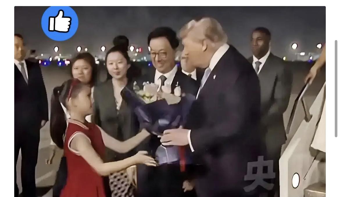 整个接机仪式中最引人注目的就是那个穿红色连衣裙的小姑娘，手里捧着花，在满是黑压压