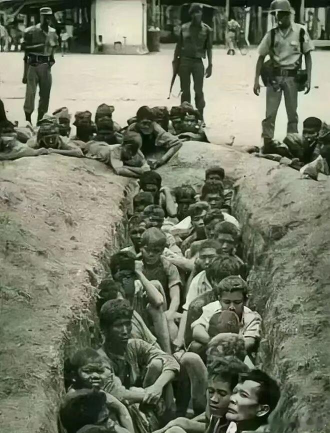 发生在1965年的印尼，一幕荷枪实弹的士兵包围了一个坑，里面坐满了华人，而这些华