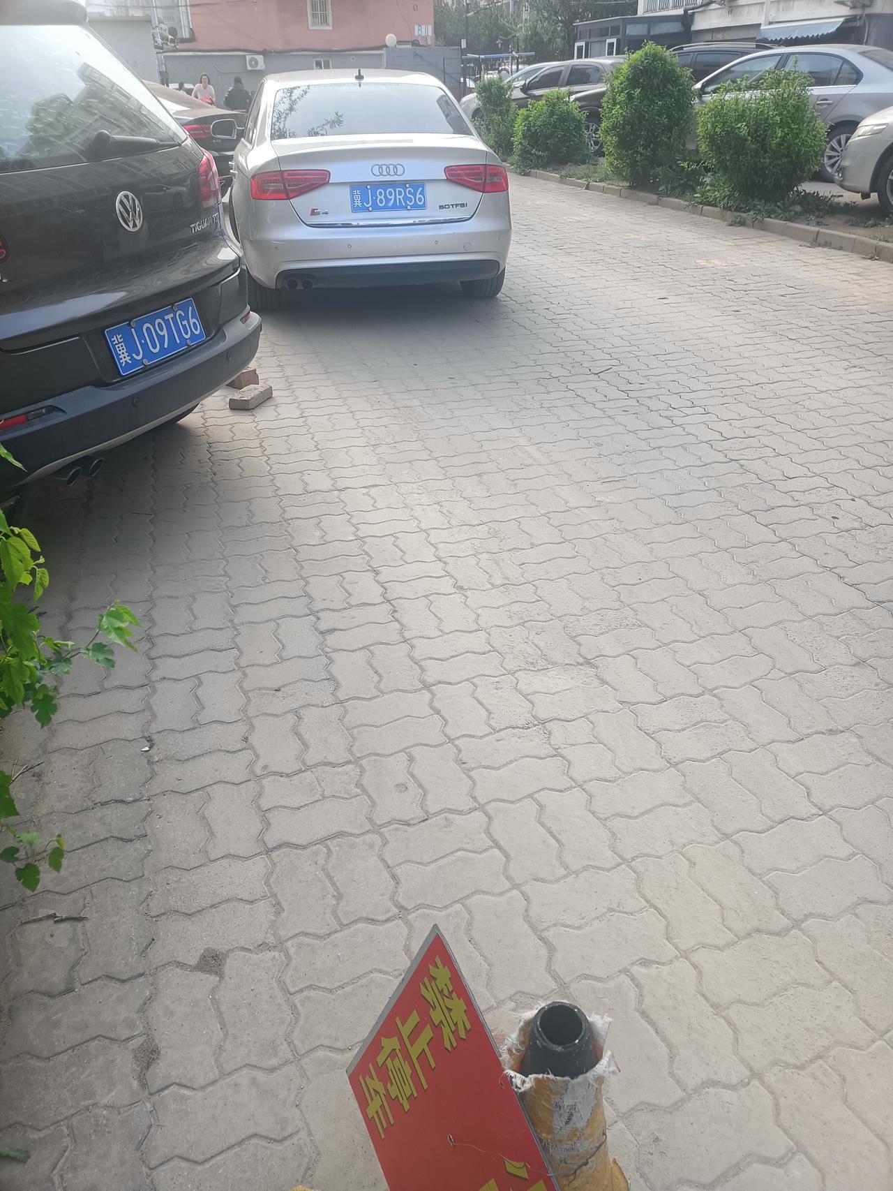 这辆灰色奥迪就这样停在小区出口处，占了一个车道，于是这条路变成了单行道。
骑电车