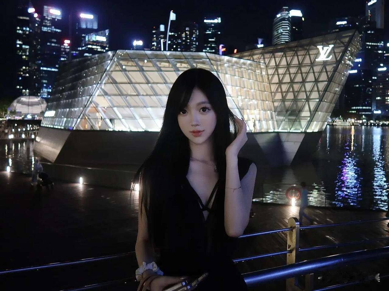 夜景下，女孩靠在栏杆旁，城市灯光璀璨。