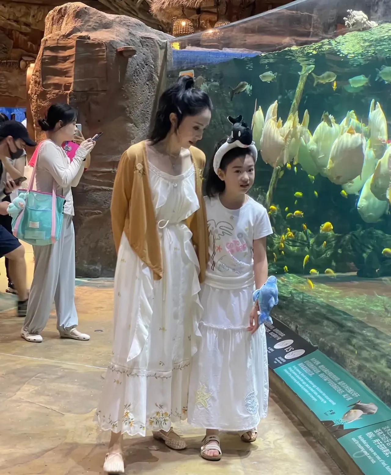 董璇与小酒窝逛珠海长隆海洋王国，
小酒窝头戴海豚发卡很可爱，
董璇白底碎花裙子配
