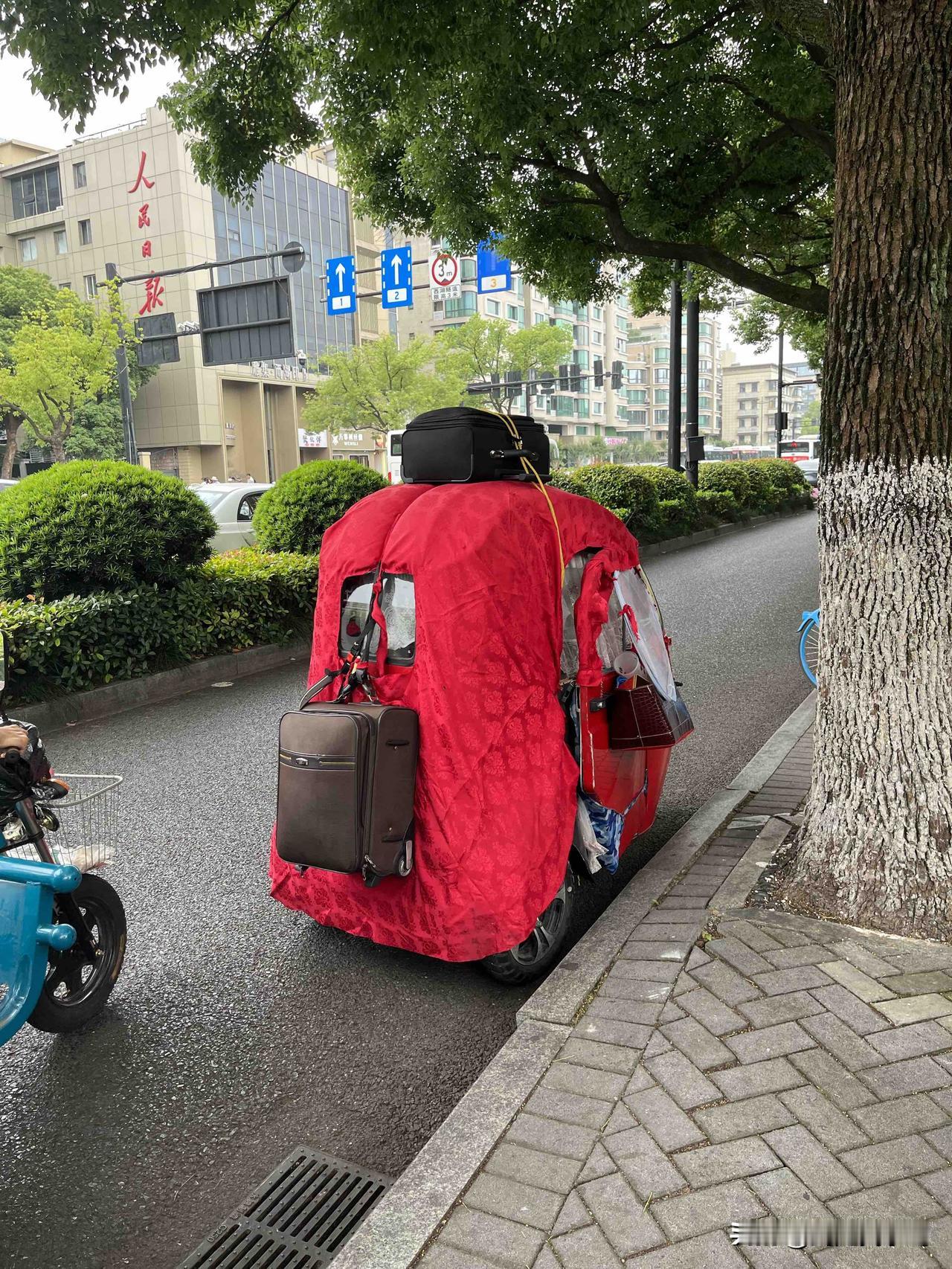 车主一定是个有故事的人 杭州西湖，这辆车子停在杭州西湖边的路边，车身上悬挂着行李