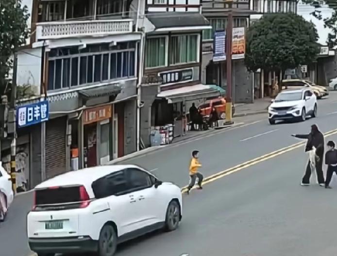 小孩飞奔过马路被车撞倒拖行数米，家属情绪激动晕倒，众人抬车救人
双黄线横穿马路，