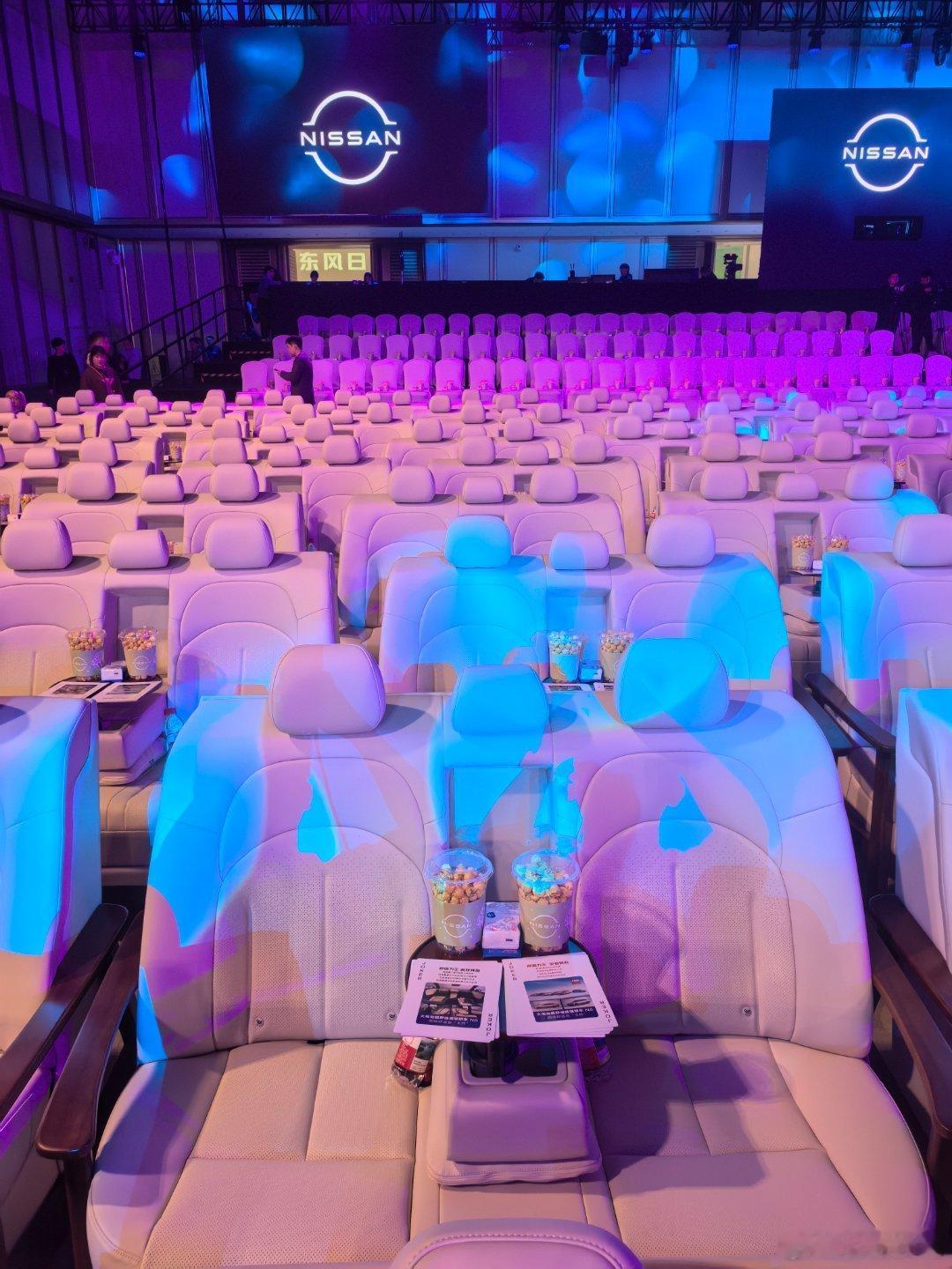东风日产太会整活了日产N6上市会现场几百张座椅用的是N6后排座椅还在小桌板上摆满