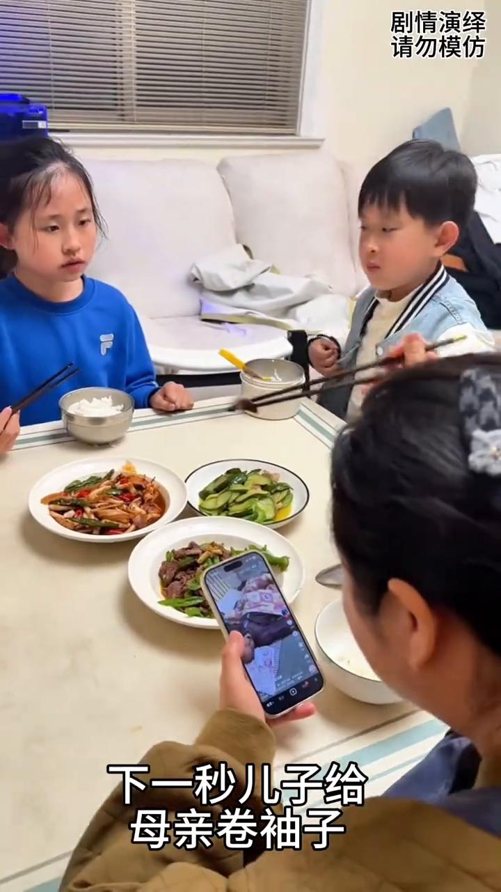 母亲夹肉伸向姐弟两个。
一家人正在吃晚饭，这时母亲夹着肉伸向姐弟两个人。谁知姐姐