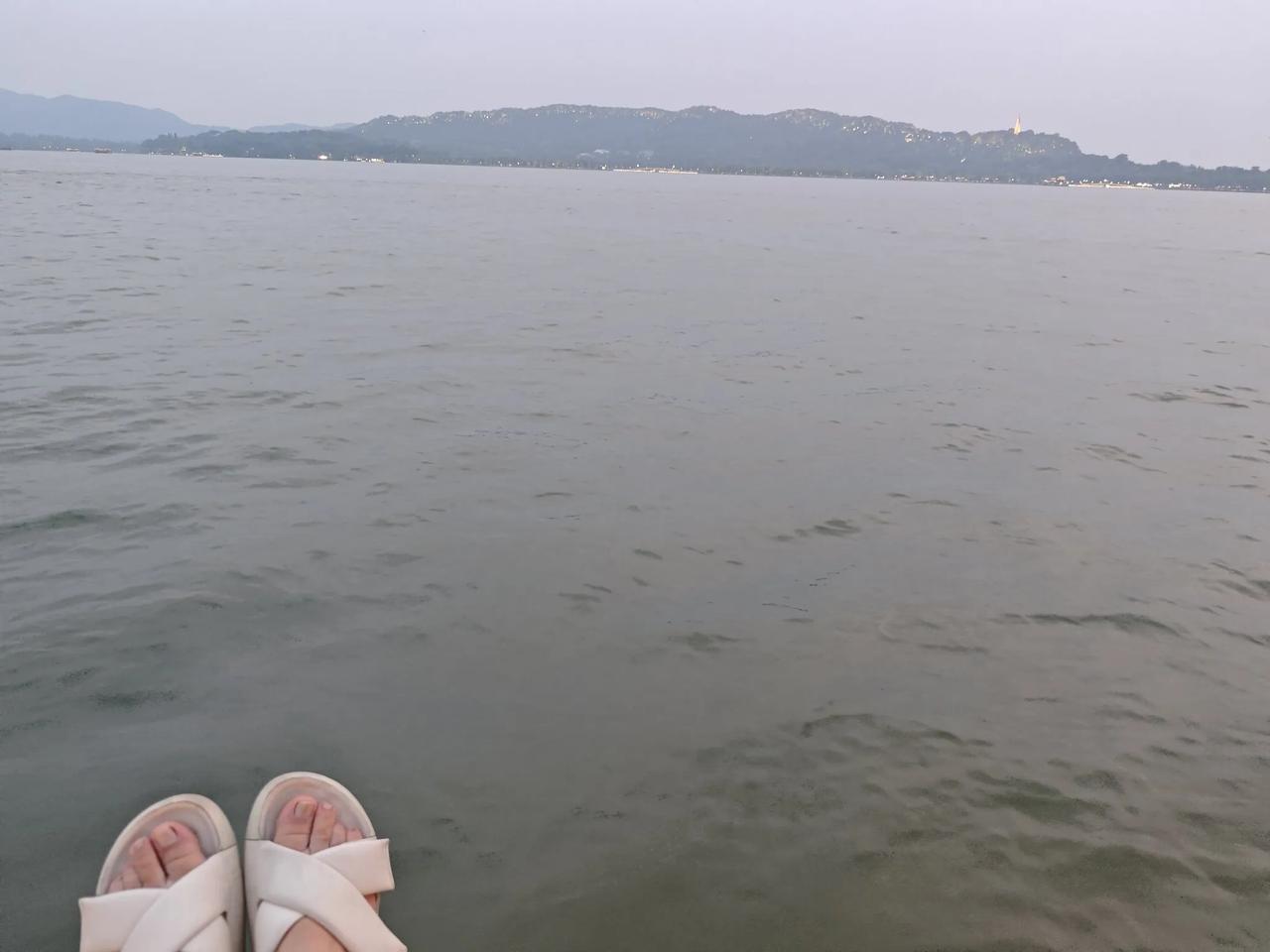 坐在九曲桥的石凳上看着西湖美丽的夜景，缓缓流动的湖水，心情是多么的惬意，哪怕是呆