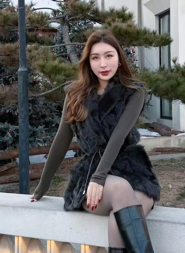 冬日暖阳下，优雅女子倚栏而坐，毛绒外套与红唇相映！