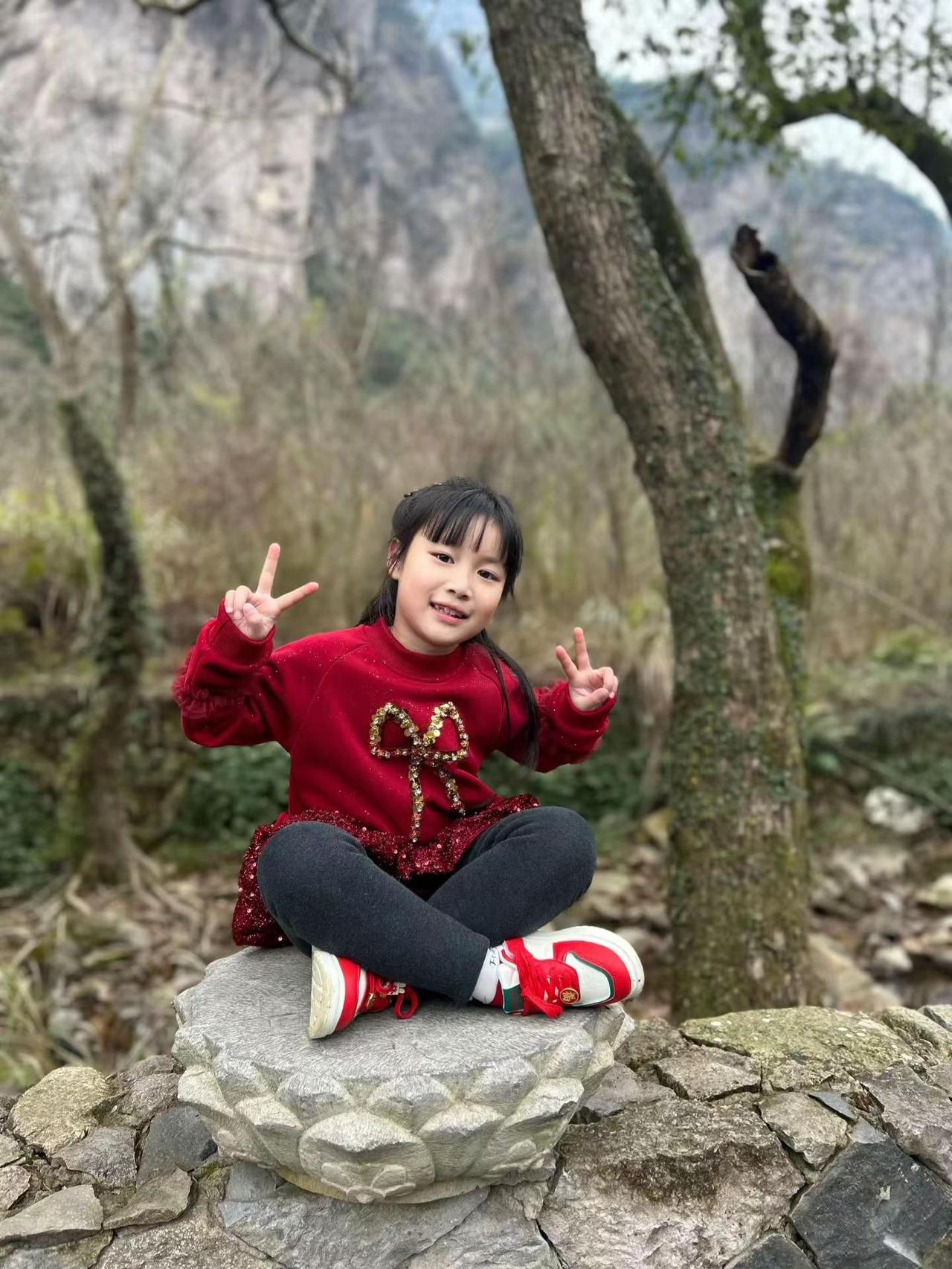 🎉小公主今天甜度超标啦！👑红衣蝴蝶结配上山间灵气，比心都带着光✨ 新的一岁要