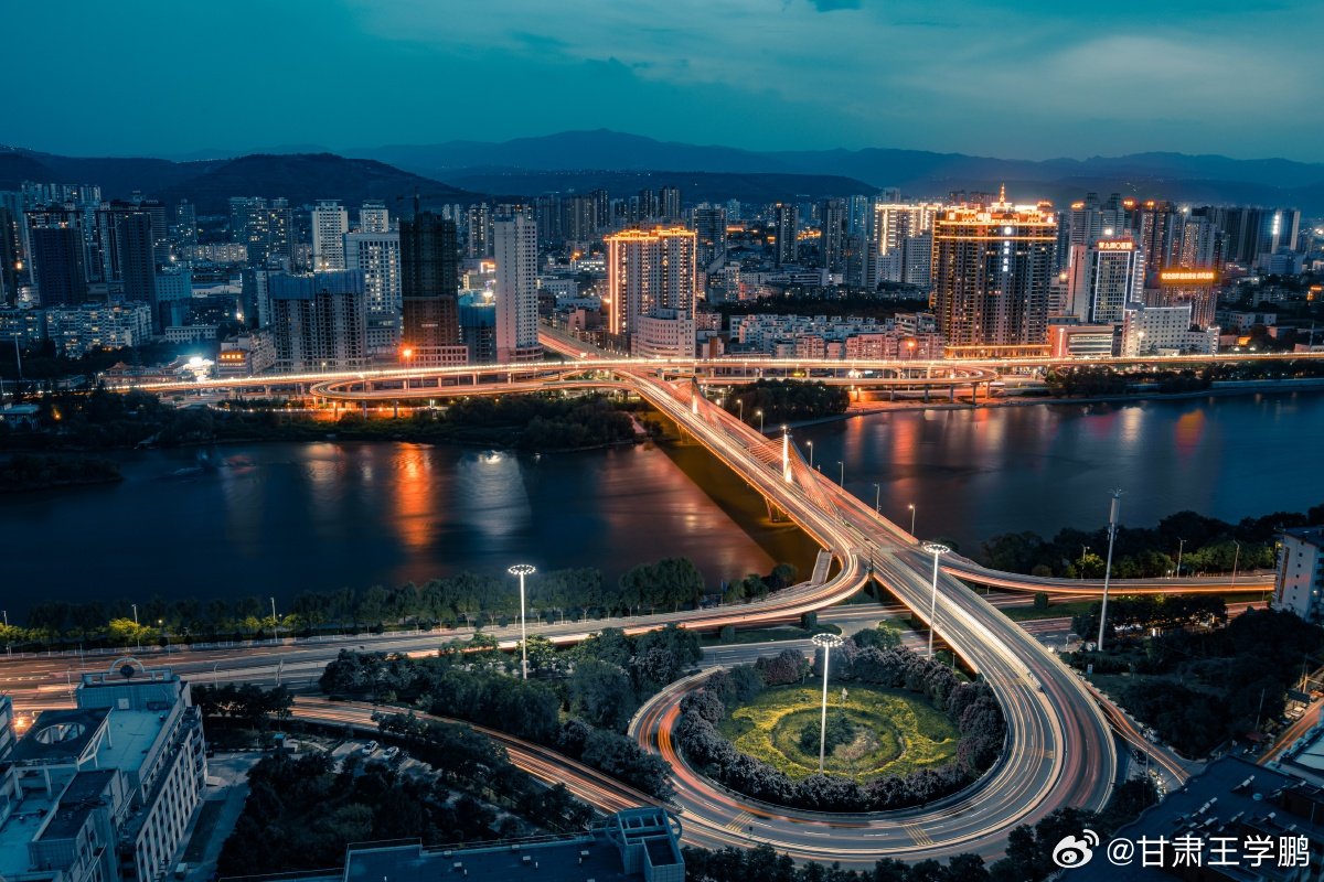 跨河大桥串联起兰州的日与夜白日矮塔斜拉桥静静伫立，车流奔赴城市各处；夜色桥塔流光