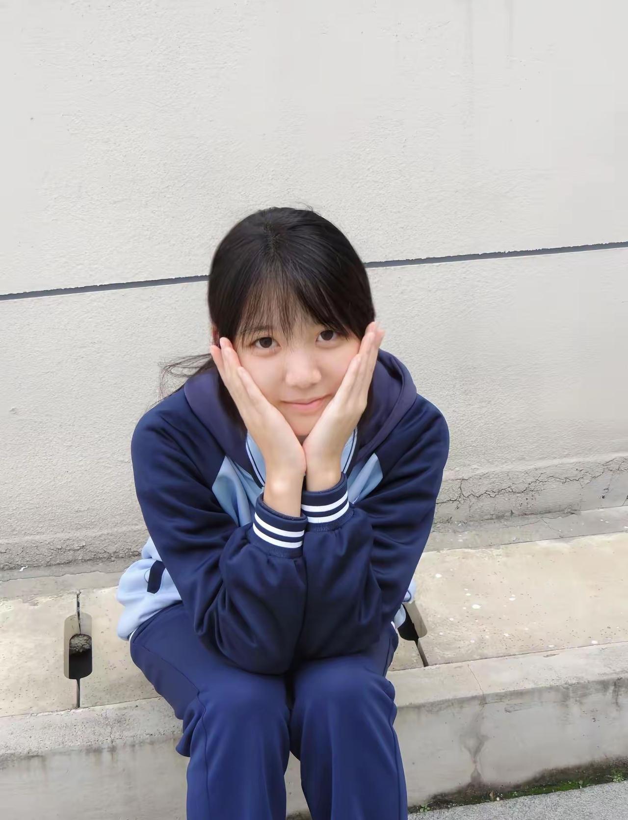 这姑娘坐那墙边，手托着脸笑呢。小姑娘微笑 仰头舒展之美女 侧倚美女