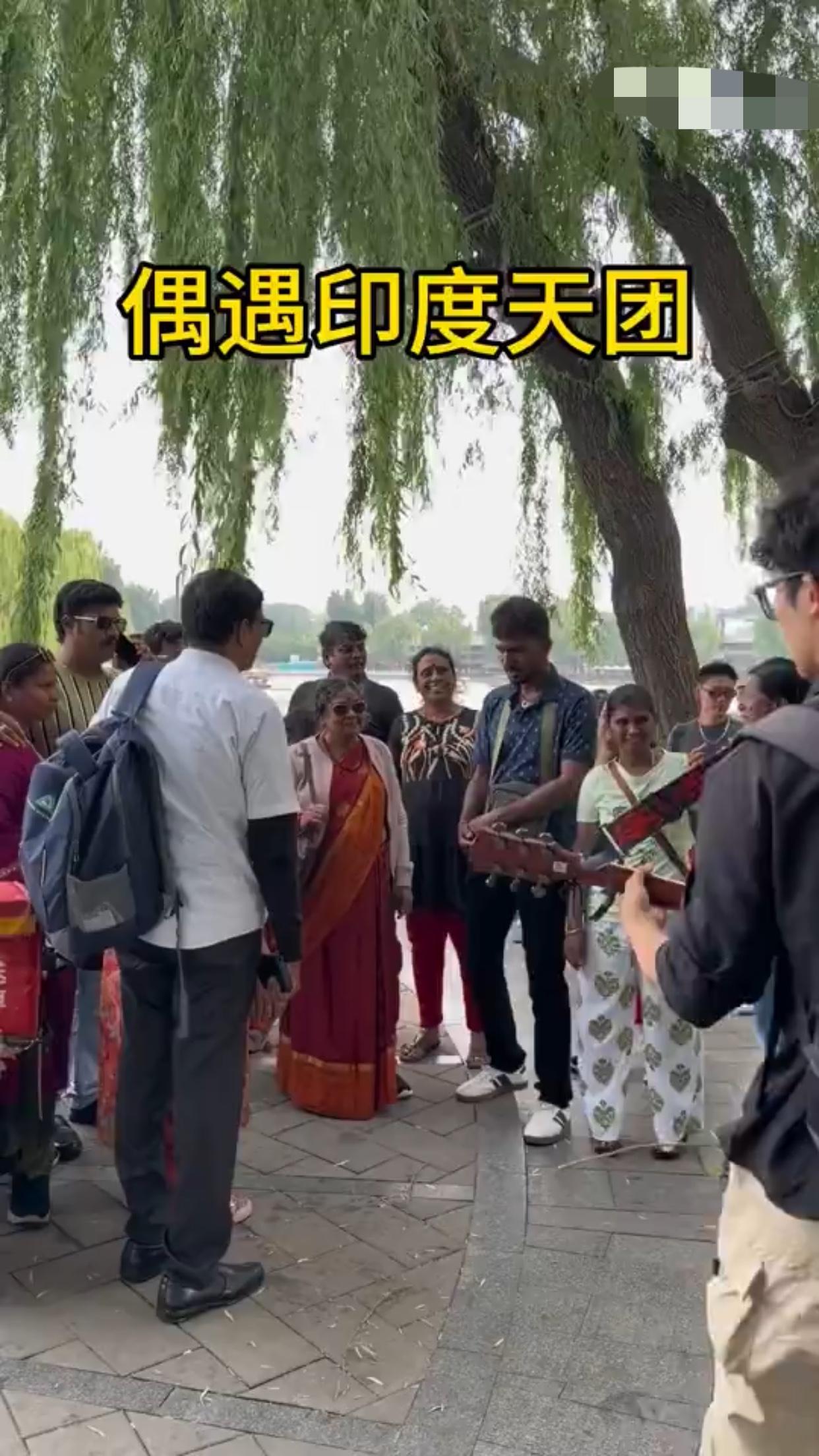 在街道边弹吉他的网红男子主动为路过的印度来华旅行团弹奏印度传统曲子，这些印度人刚