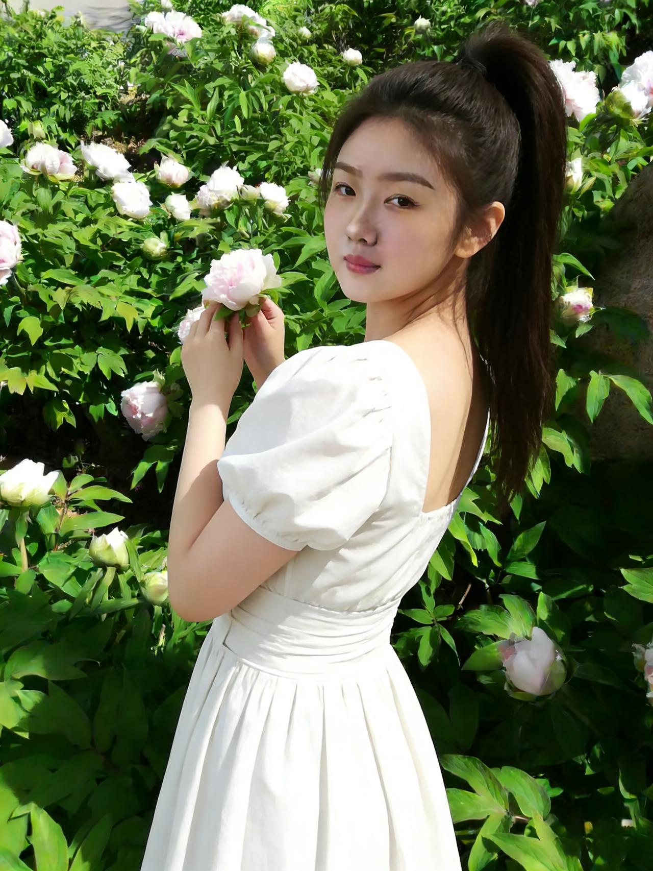 独立芍药中，素裙趁晓风。
肩白牵蝶影，腰细束春容。
步缓香尘软，眸清玉露浓。
转