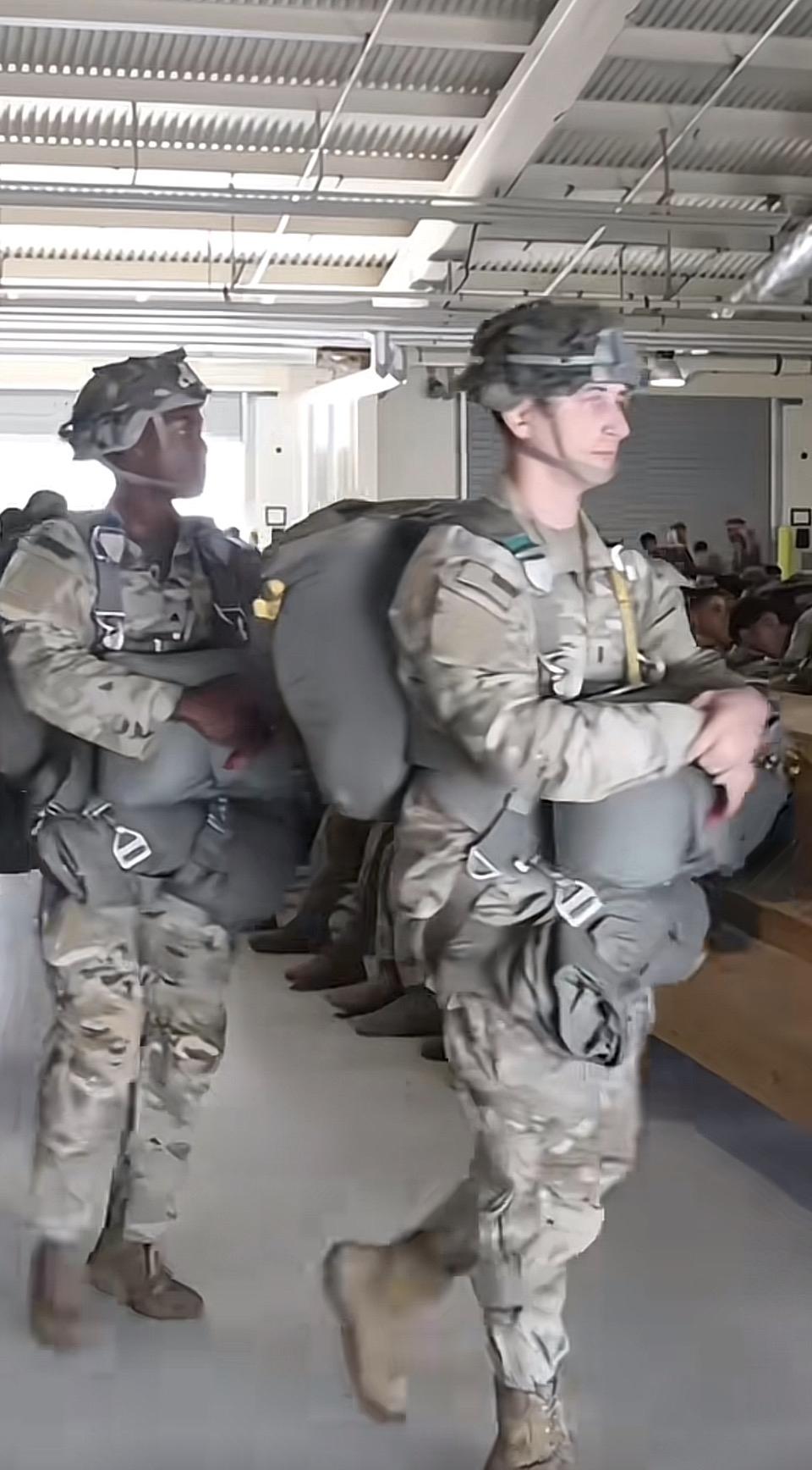 两位士兵背着装备在室内行走。