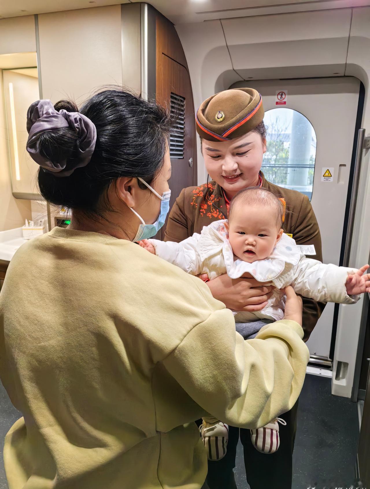 G1116次列车员王妍帮助旅客照看孩童。（周慧宇） ​​​
